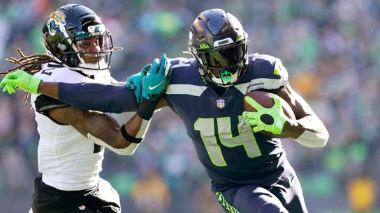 Steelers wide receiver DK Metcalf stiff arms a defender during a game. 