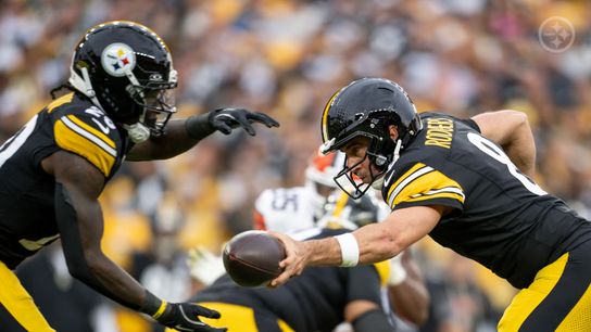 Steelers rookie running back Kaleb Johnson (20) prepares to receive a handoff from veteran quarterback Aaron Rodgers (8) during a regular season game against the Cleveland Browns.